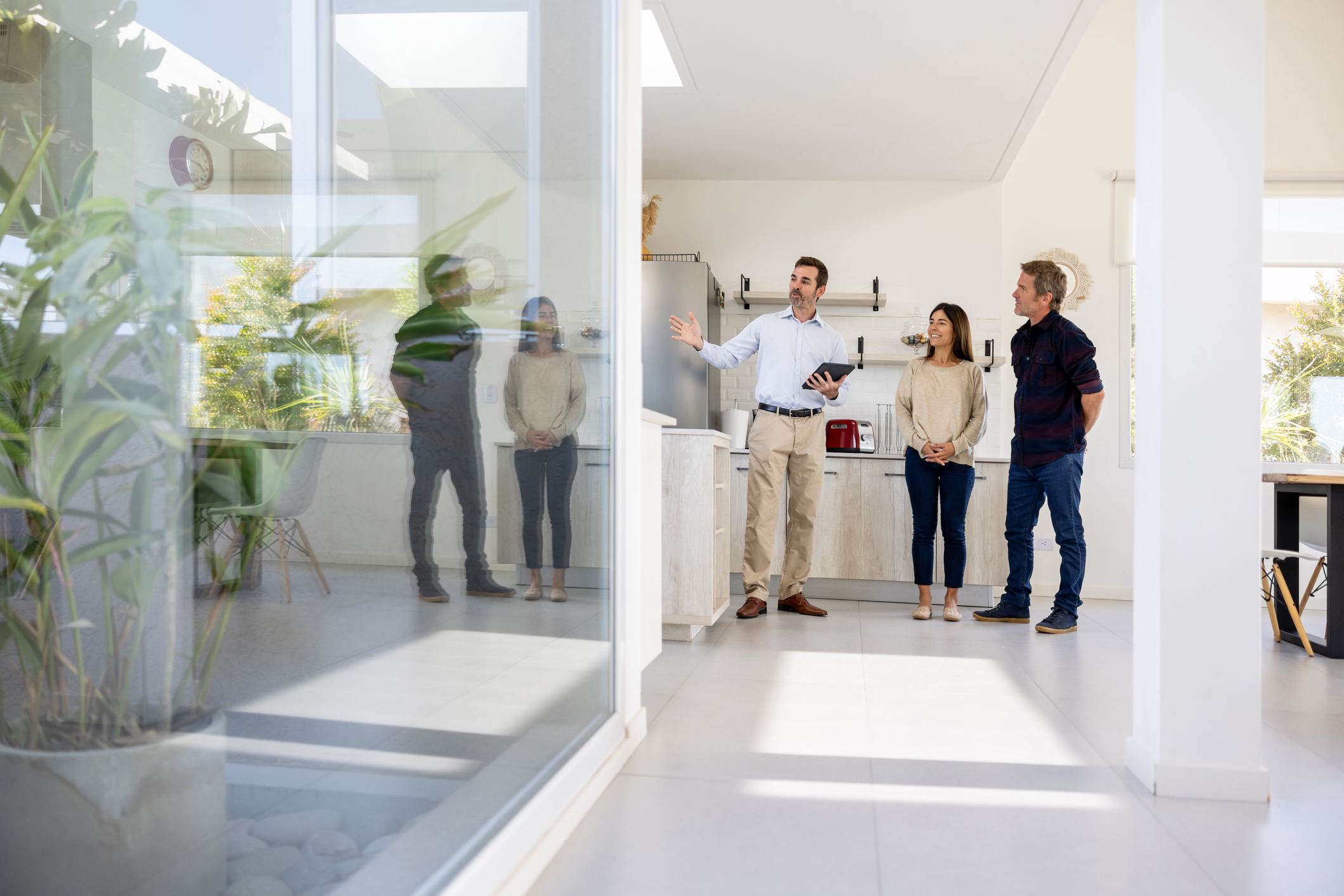 Real estate agent showing a house for sale to a couple